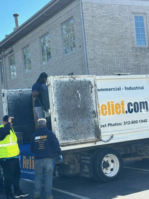 JUNK Relief crew loading items into the truck at a real estate office junk drive