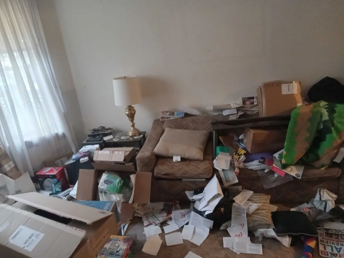 Before: front room piled with papers and boxes (estate cleanouts, North Center)