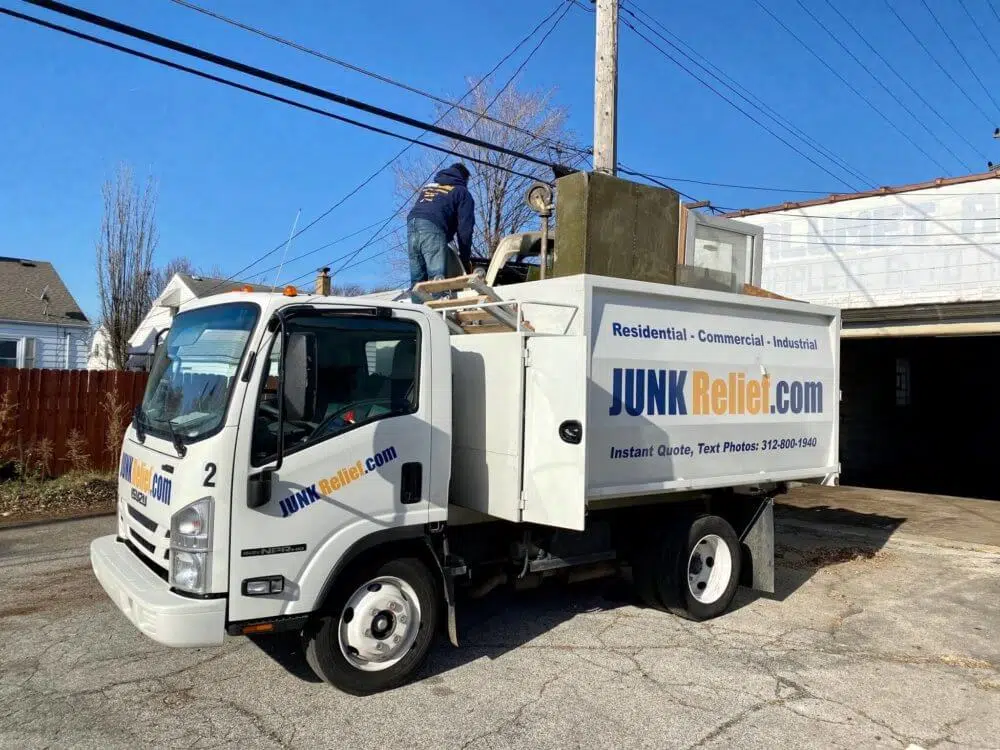 Junk Removal Specialists finish loading a junk removal truck fully packed with old furniture and junk | JunkRelief.com Chicago