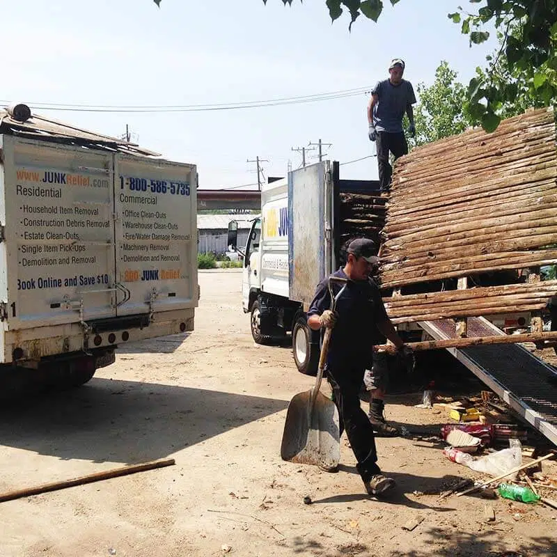 demolished Fence section being loaded on to a junk removal truck during a fence removal project | Junk Relief Chicago