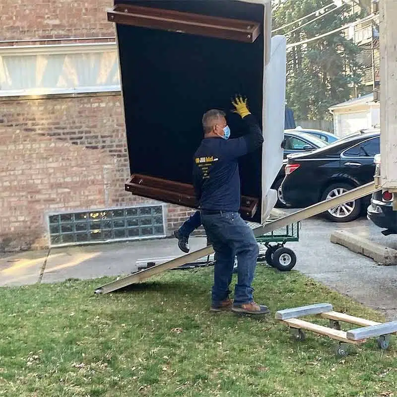 A Junk Removal Specialist carrying a couch up the truck ramp during a Furniture Removal near Elmhurst | Junk Relief Chicago