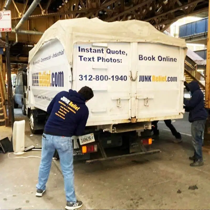 Junk removal specialist closing a truck with a tarp during a electronics and tv recycling project in Chicago | Junk Relief Chicago