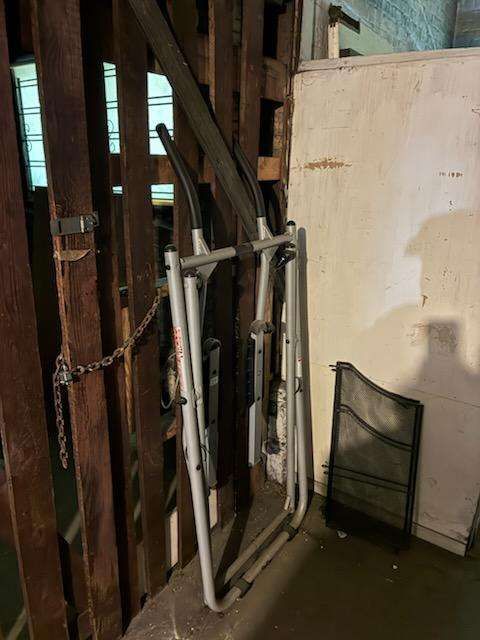 Before: exercise equipment and paneling against the wall