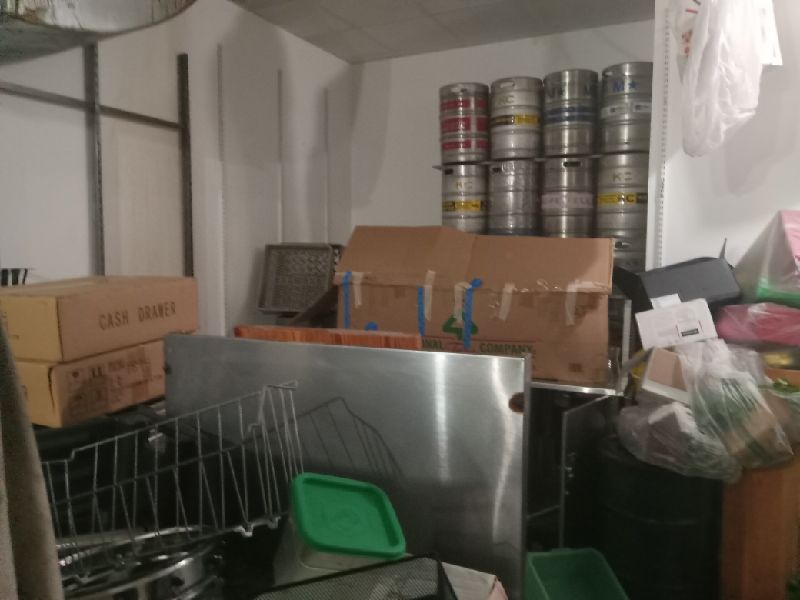 Before: kegs, prep tables and boxed goods in the back of house