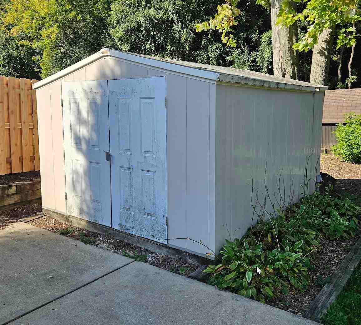 Before: the 10x12 PVC shed by the driveway