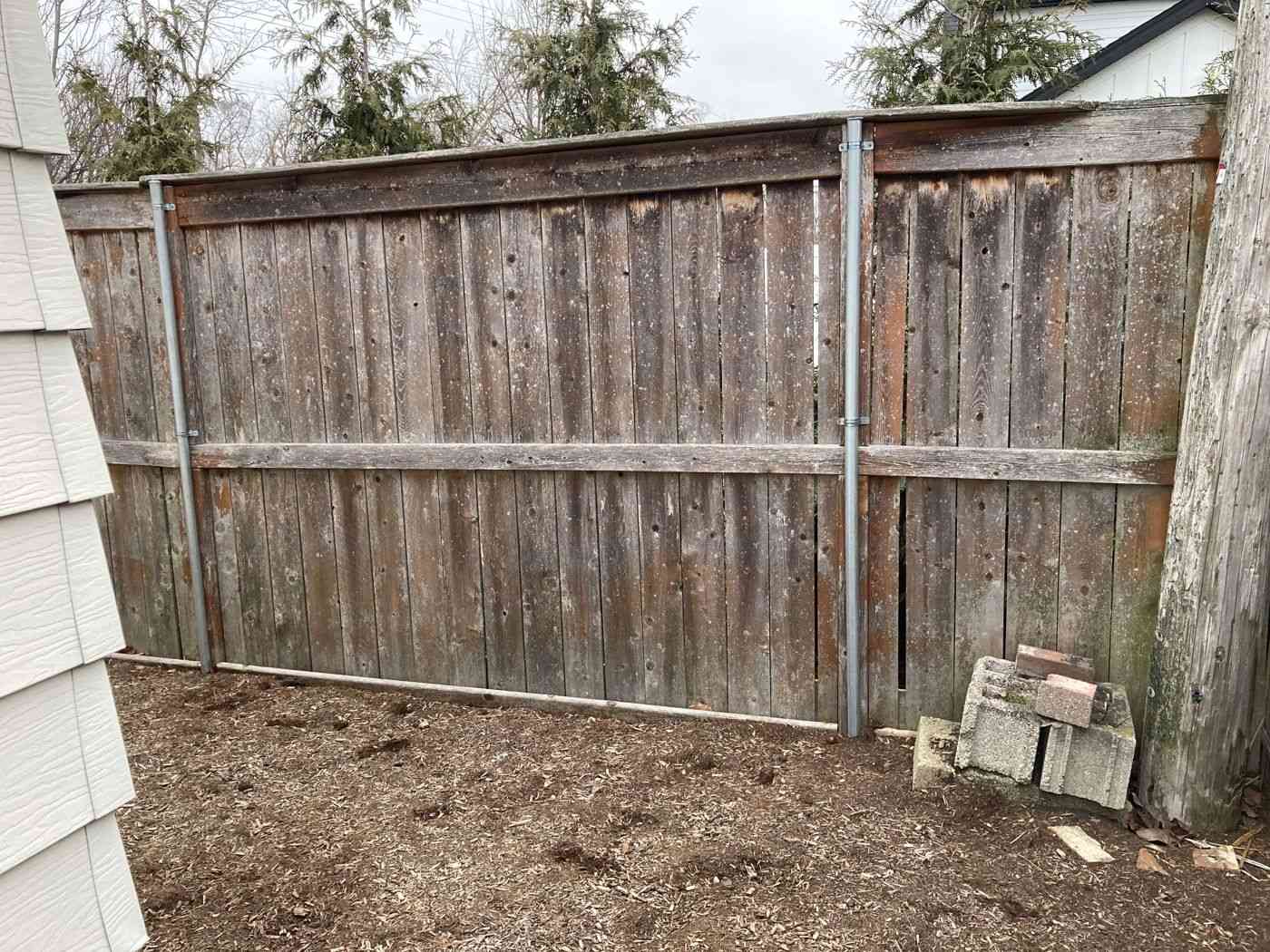 Before: weathered 6-ft privacy fence along the south side